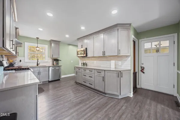a kitchen with stove cabinets and wooden floor