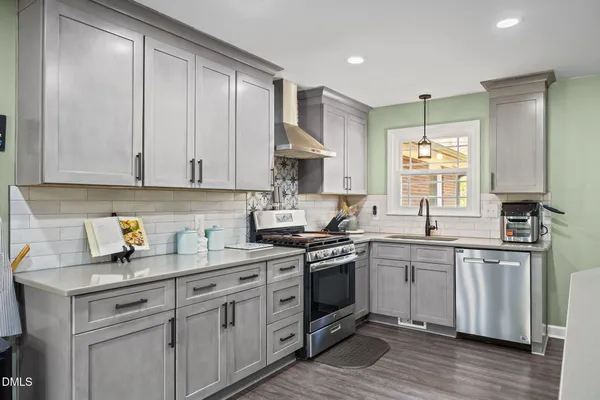 a kitchen with stainless steel appliances granite countertop a sink stove and cabinets