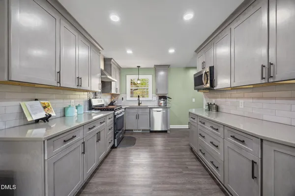 a kitchen with kitchen island granite countertop stainless steel appliances cabinets a sink and a counter top space