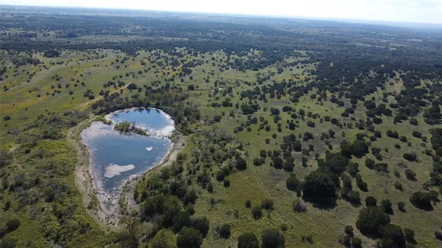 a view of a field with trees in the background