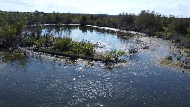 a view of a dry yard covered with snow in the background