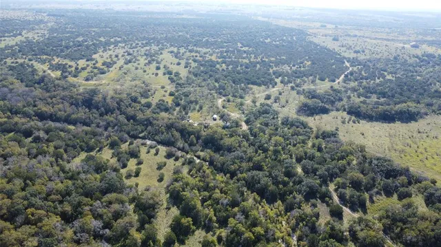 an aerial view of house with yard and mountain view in back