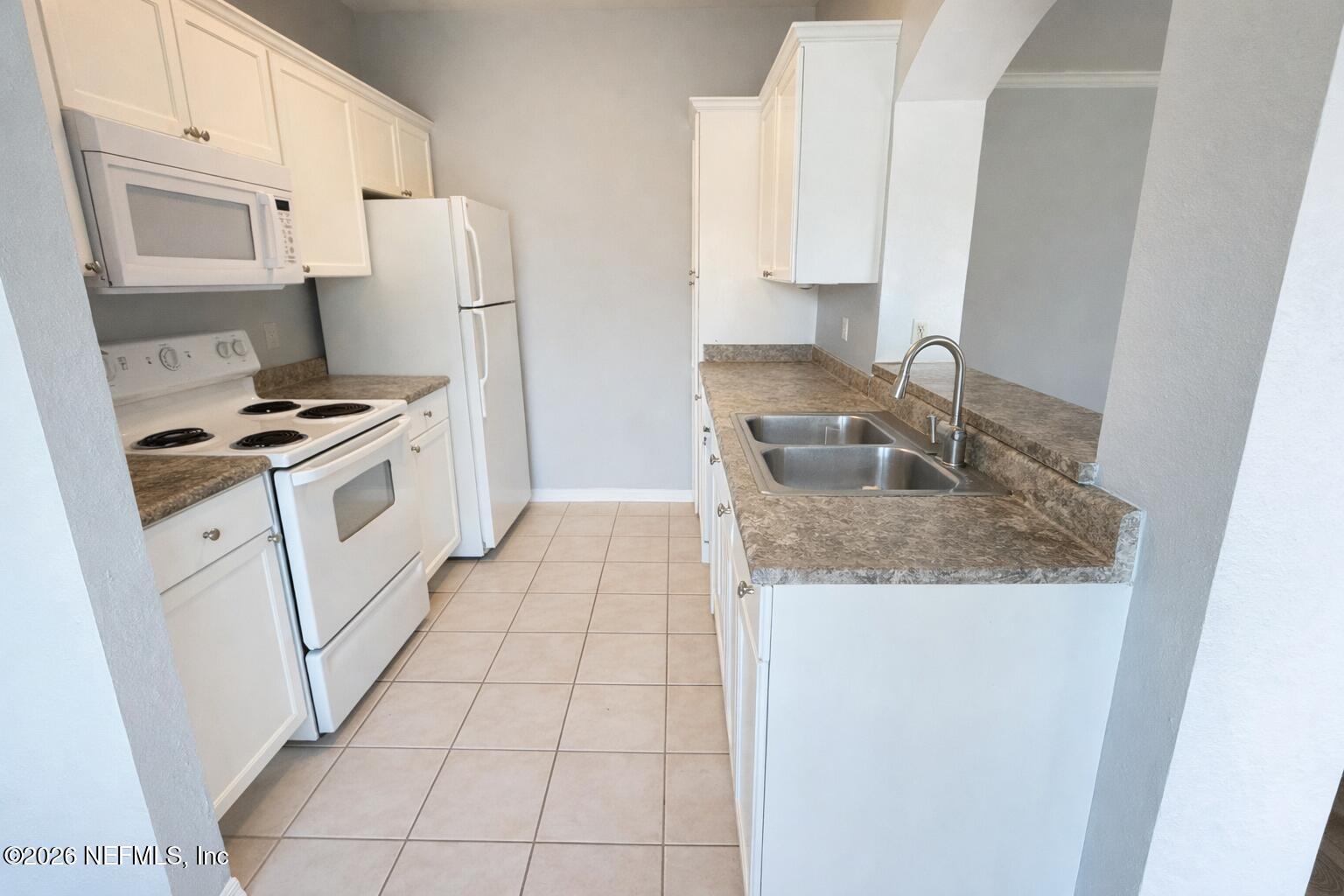 10961 Burnt Mill Road, Unit 225 Jacksonville, FL 32256 - Photo 2 of 17 a kitchen with granite countertop a sink stove and refrigerator