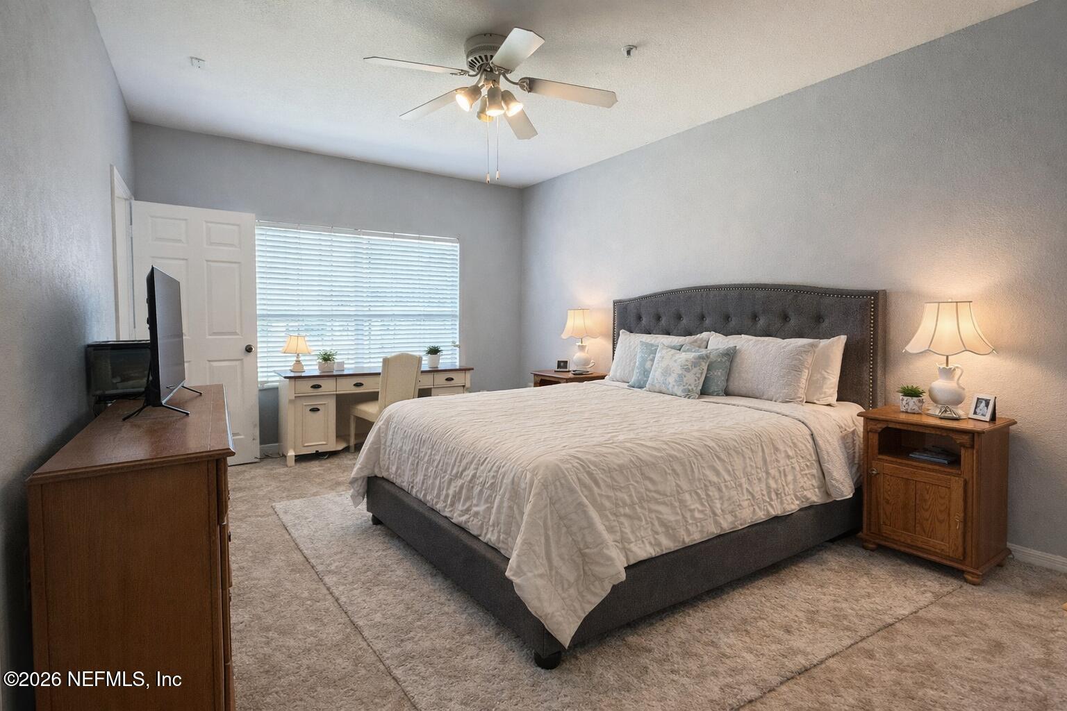 10961 Burnt Mill Road, Unit 225 Jacksonville, FL 32256 - Photo 5 of 17 a spacious bedroom with a bed and a flat screen television