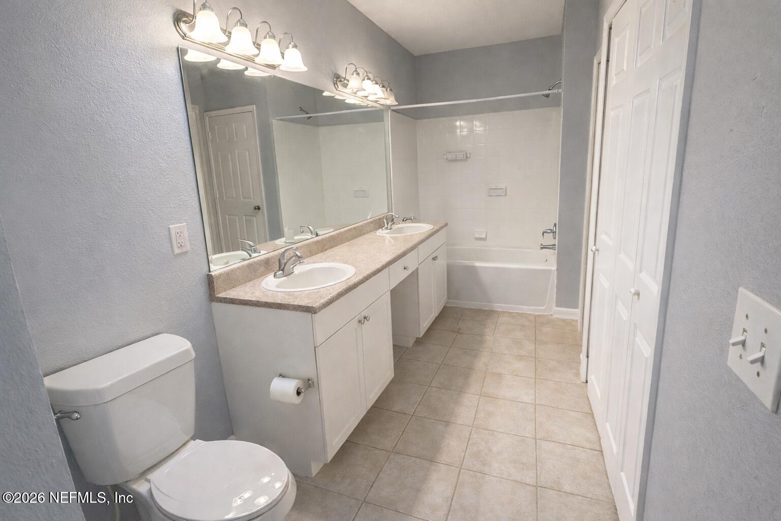 10961 Burnt Mill Road, Unit 225 Jacksonville, FL 32256 - Photo 6 of 17 a bathroom with a granite countertop sink a toilet a mirror and shower