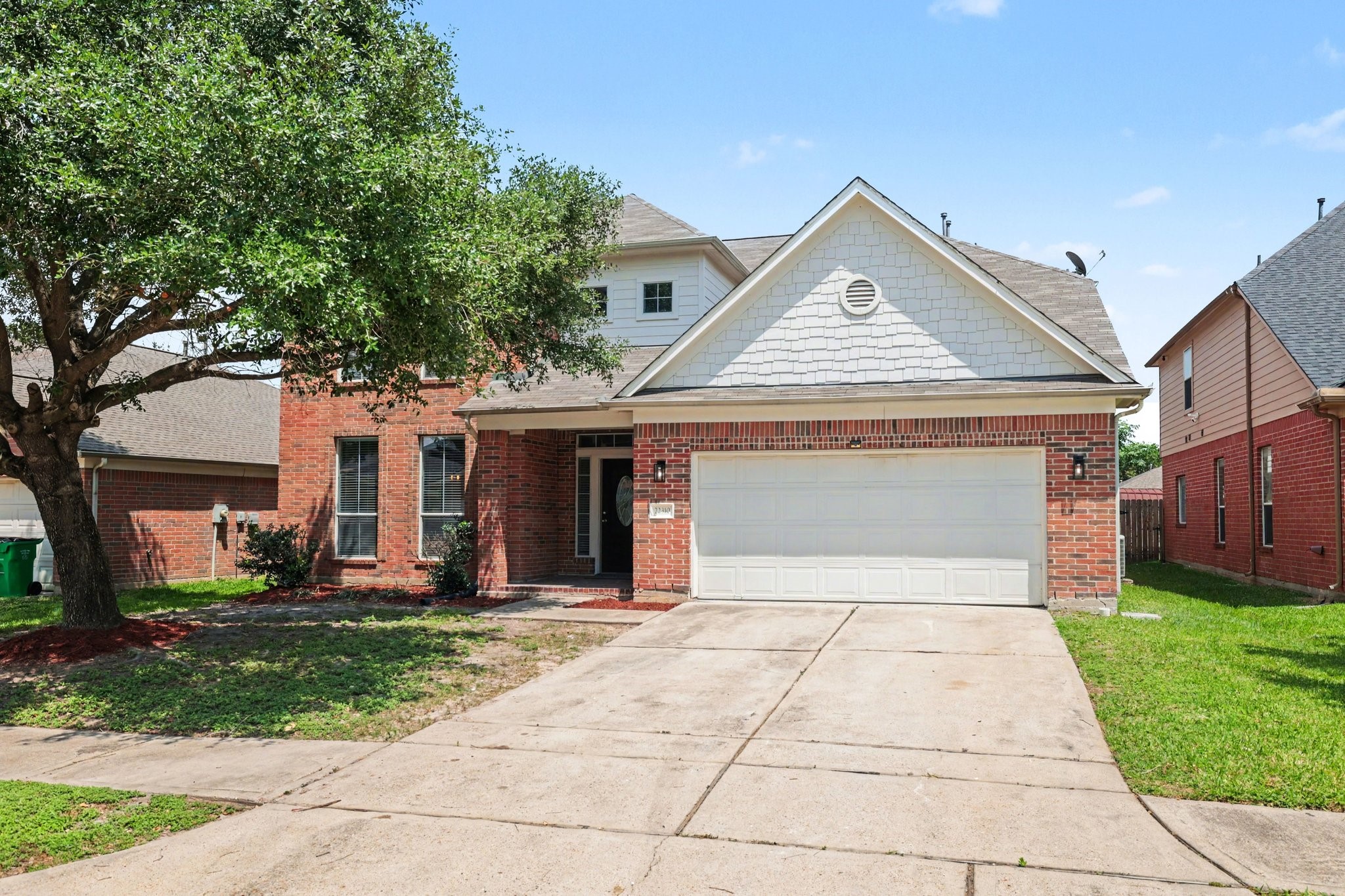 22310 Lamaster Lane Spring, TX 77373 - Photo 2 of 48 This photo shows a charming two-story brick house with a two-car garage. The front features a mature tree and double wide driveway.