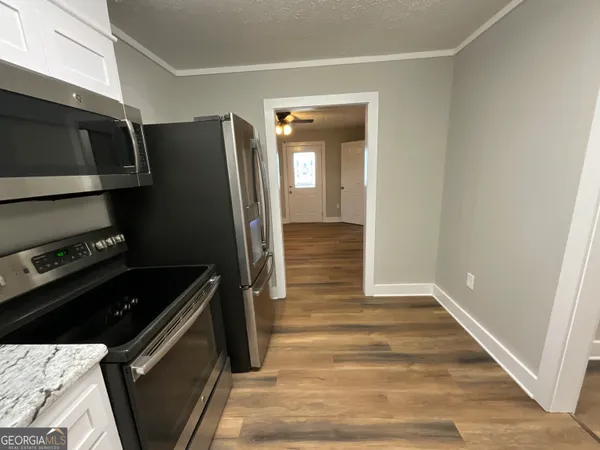 a kitchen with a refrigerator and a stove top oven