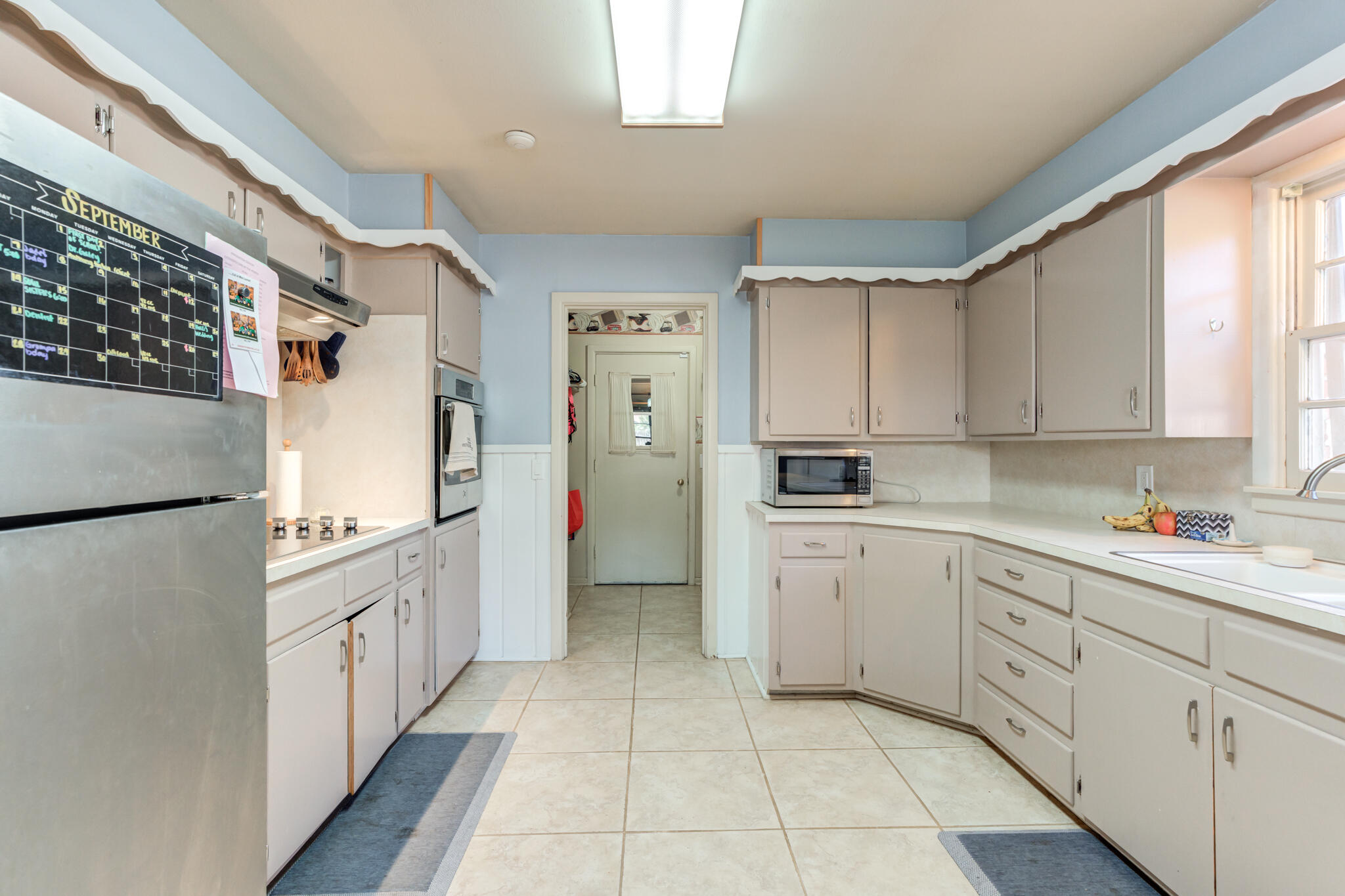 2132 69th Street Lubbock, TX 79412 - Photo 15 of 38 a kitchen with white cabinets and white appliances