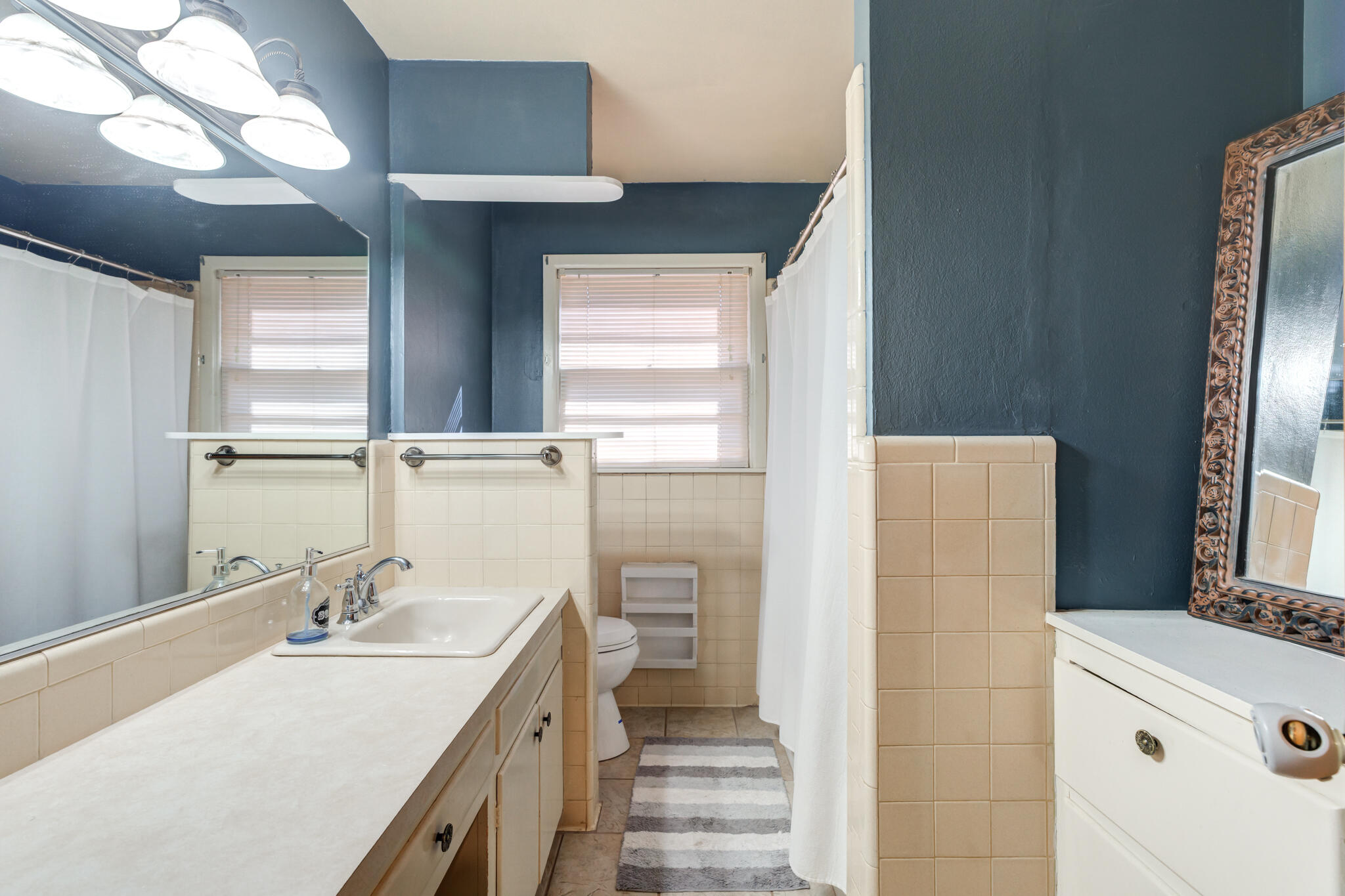 2132 69th Street Lubbock, TX 79412 - Photo 28 of 38 a bathroom with a sink a mirror and a shower
