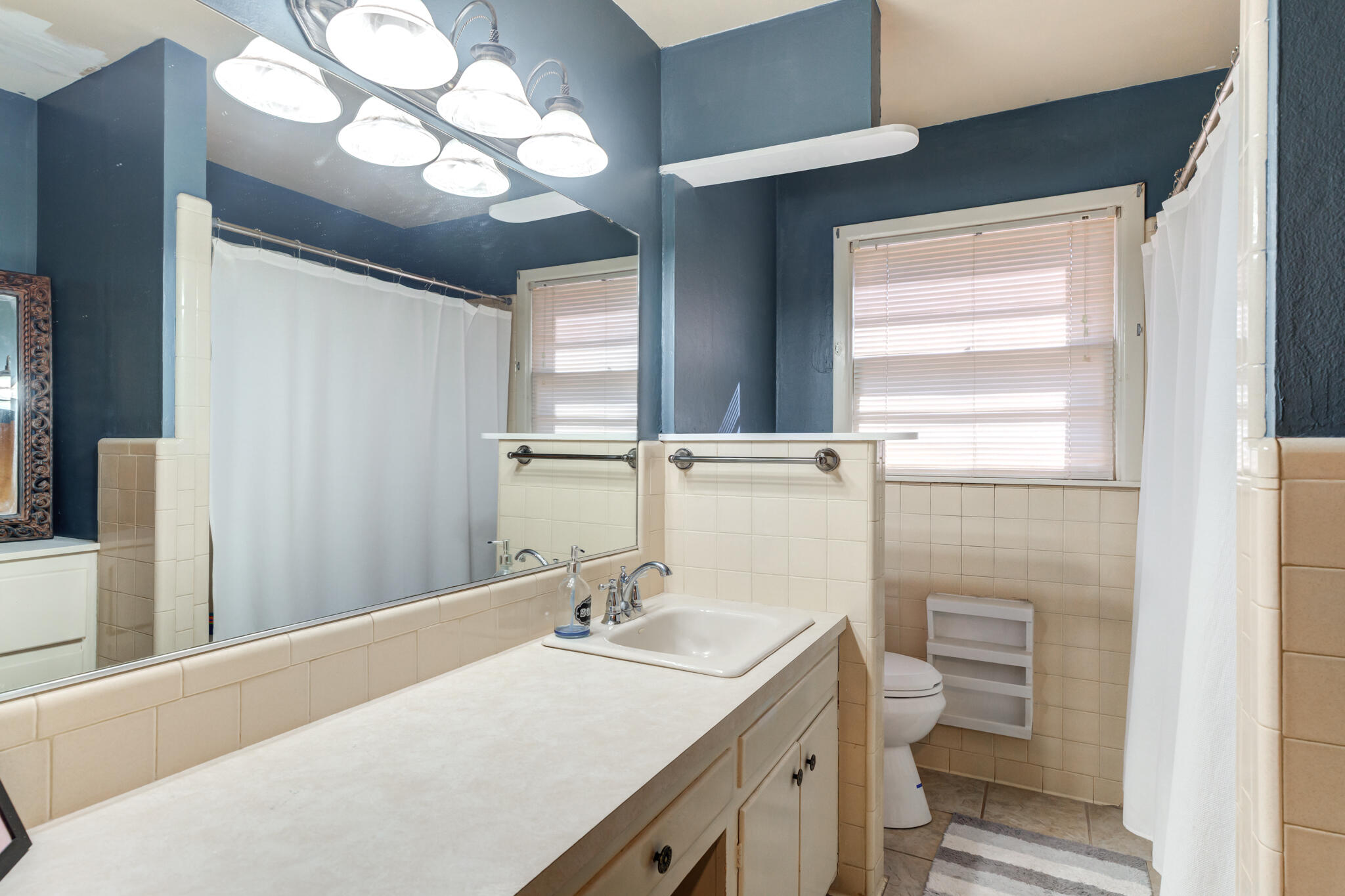 2132 69th Street Lubbock, TX 79412 - Photo 29 of 38 a bathroom with a sink a toilet and a mirror