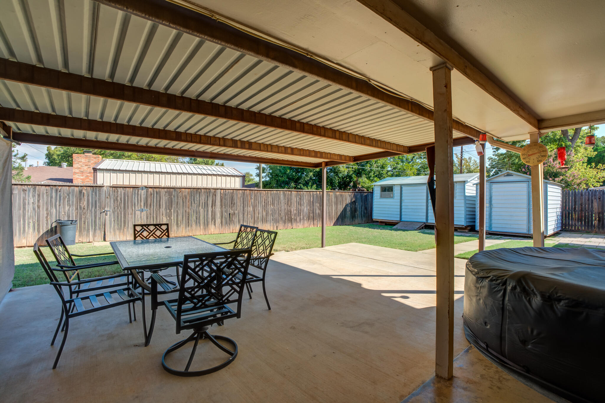 2132 69th Street Lubbock, TX 79412 - Photo 34 of 38 a view of a patio with table and chairs with wooden floor and fence