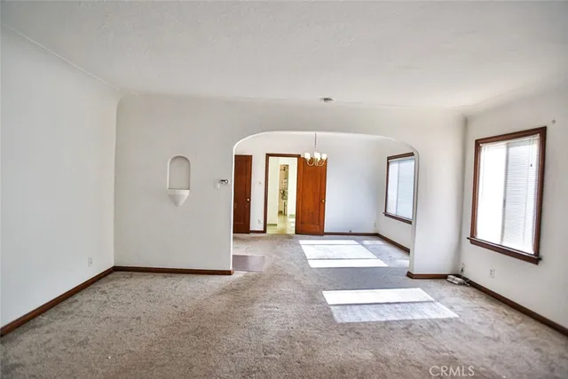 a view of an empty room with window and fireplace