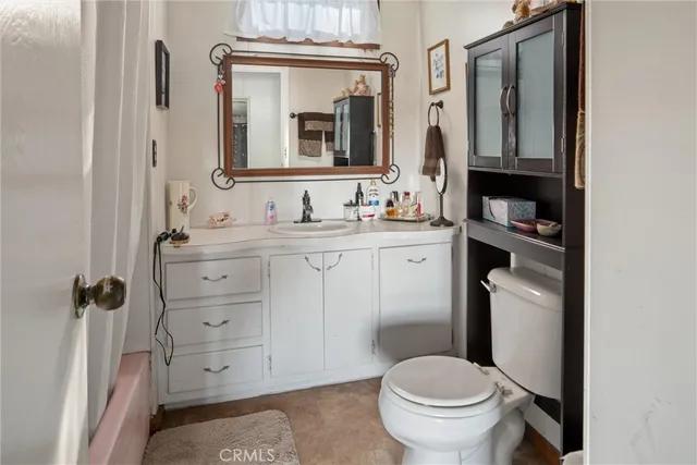 a bathroom with a toilet a sink and mirror