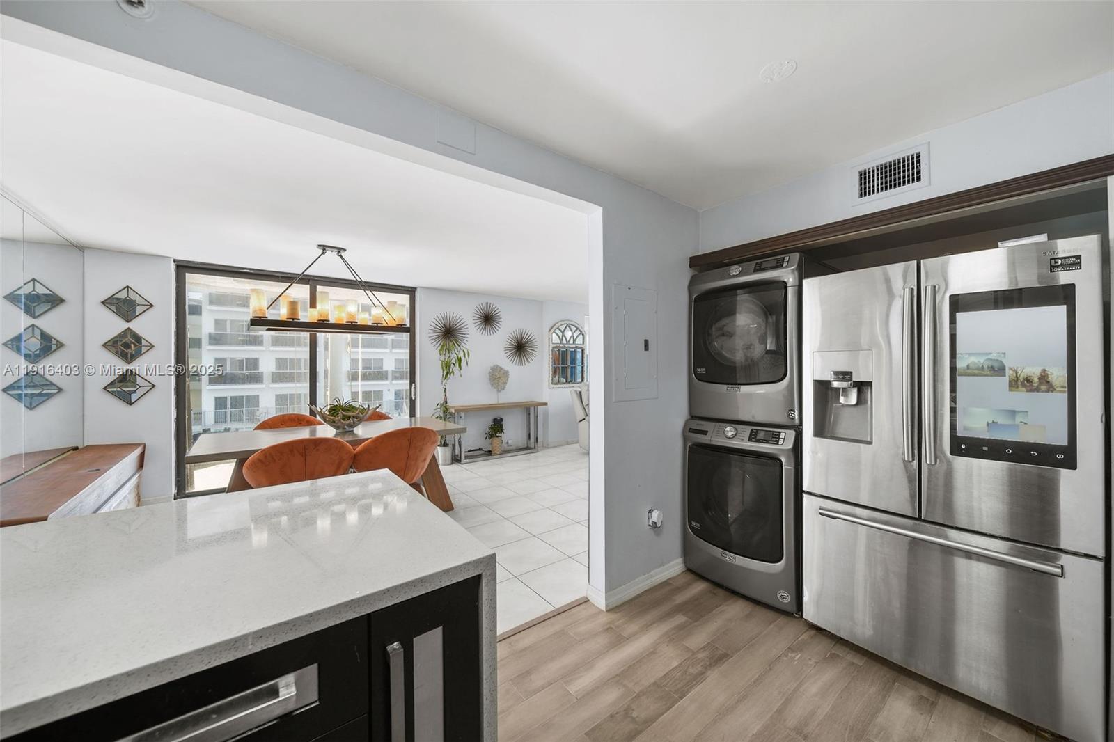 6061 Collins Avenue, Unit 5F Miami Beach, FL 33140 - Photo 13 of 26 a kitchen with stainless steel appliances granite countertop a refrigerator a stove and a sink with wooden floor