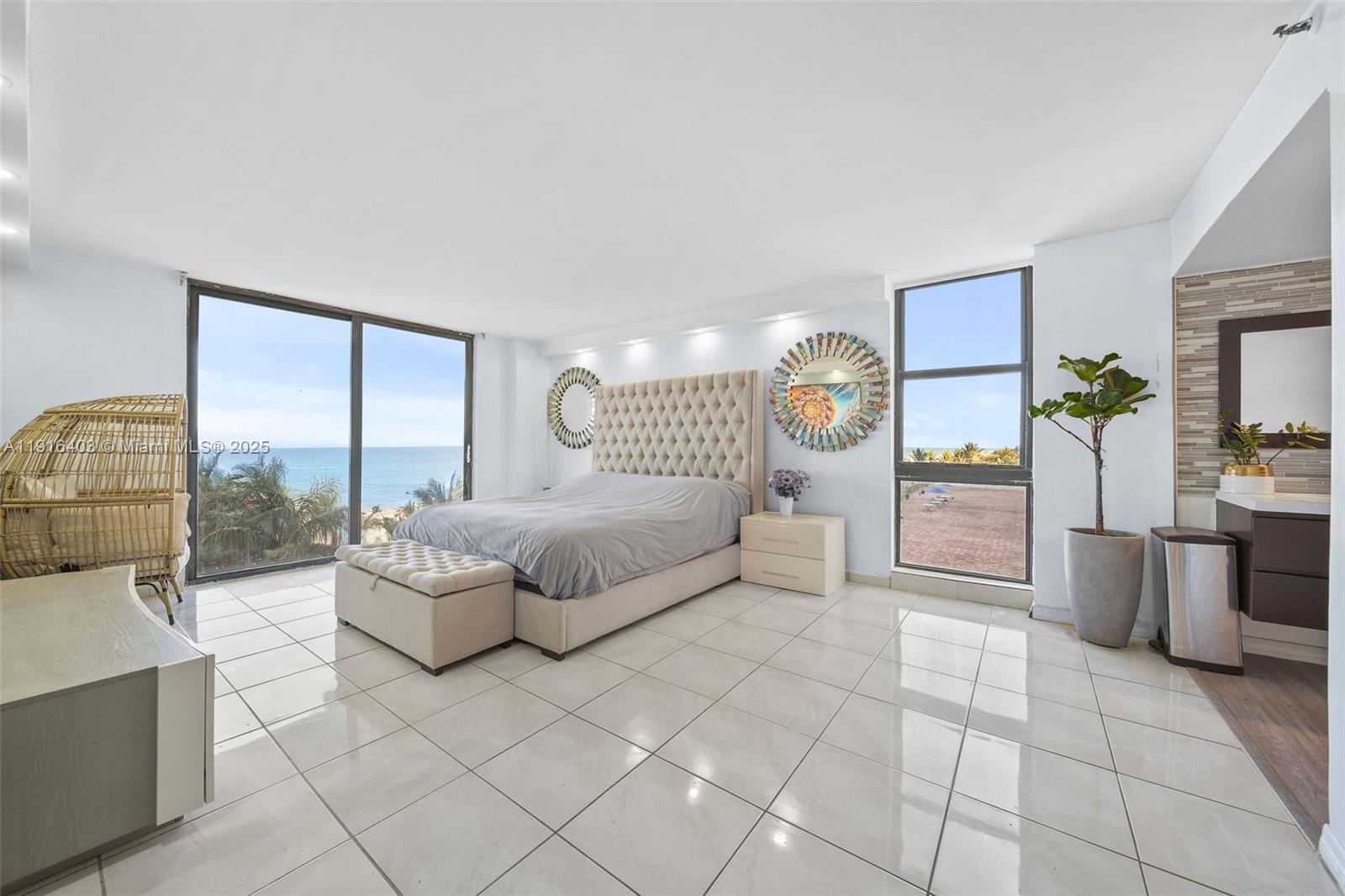 6061 Collins Avenue, Unit 5F Miami Beach, FL 33140 - Photo 16 of 26 a spacious bedroom with a large bed and a table