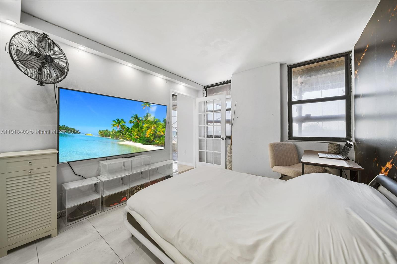 6061 Collins Avenue, Unit 5F Miami Beach, FL 33140 - Photo 20 of 26 a bedroom with a large bed and a window