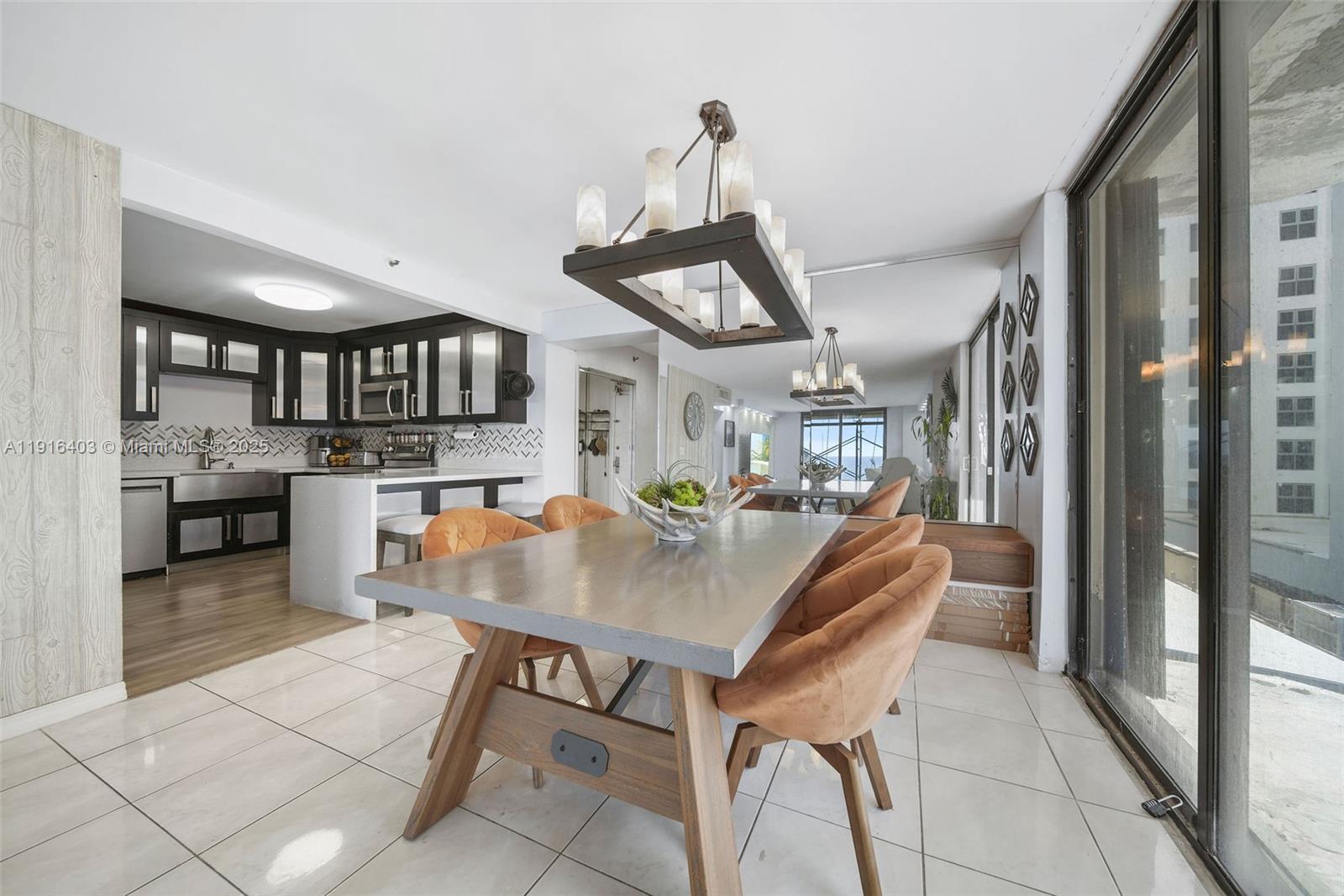 6061 Collins Avenue, Unit 5F Miami Beach, FL 33140 - Photo 9 of 26 a kitchen with a table and chairs in it