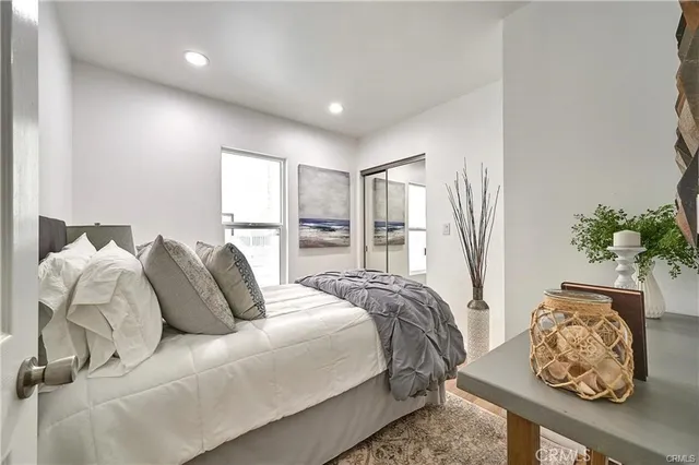 a bed sitting in a bedroom next to a window with potted plant