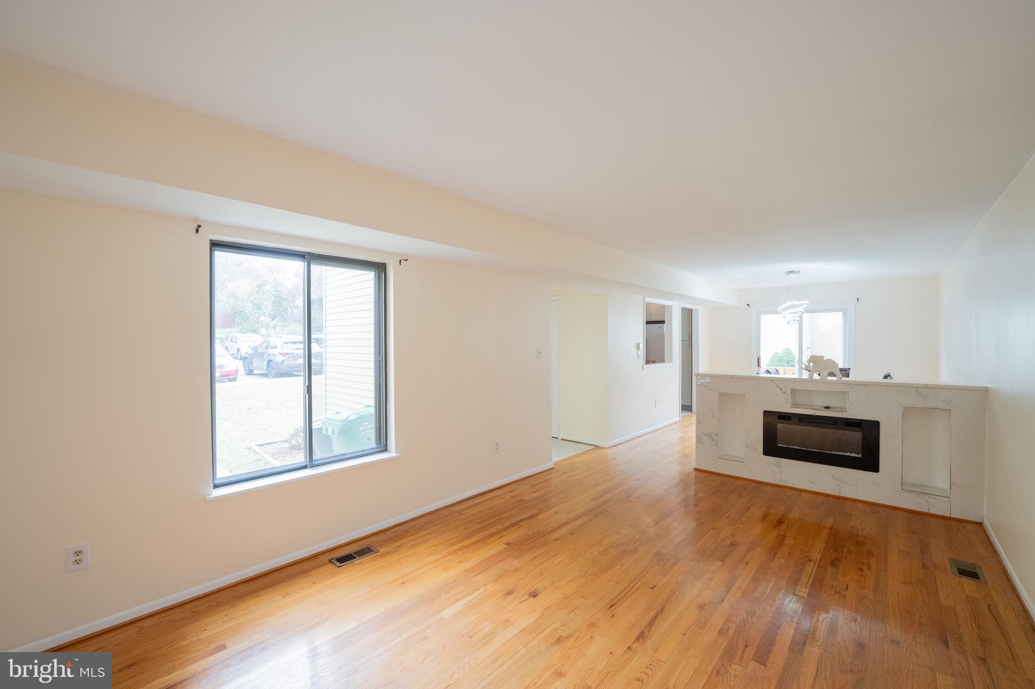 10 Brian Court, Unit 242 Gaithersburg, MD 20877 - Photo 4 of 28 wooden floor fireplace and windows in an empty room