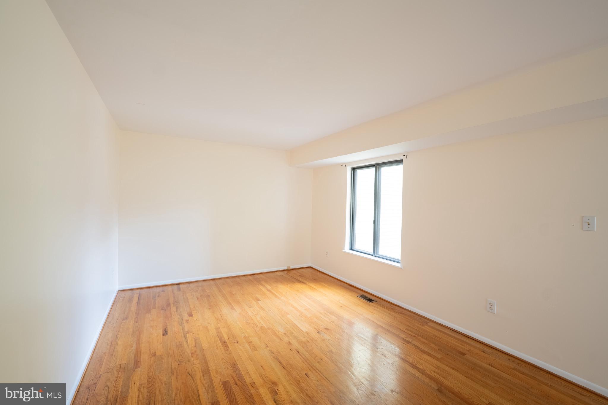 10 Brian Court, Unit 242 Gaithersburg, MD 20877 - Photo 8 of 28 an empty room with wooden floor and windows