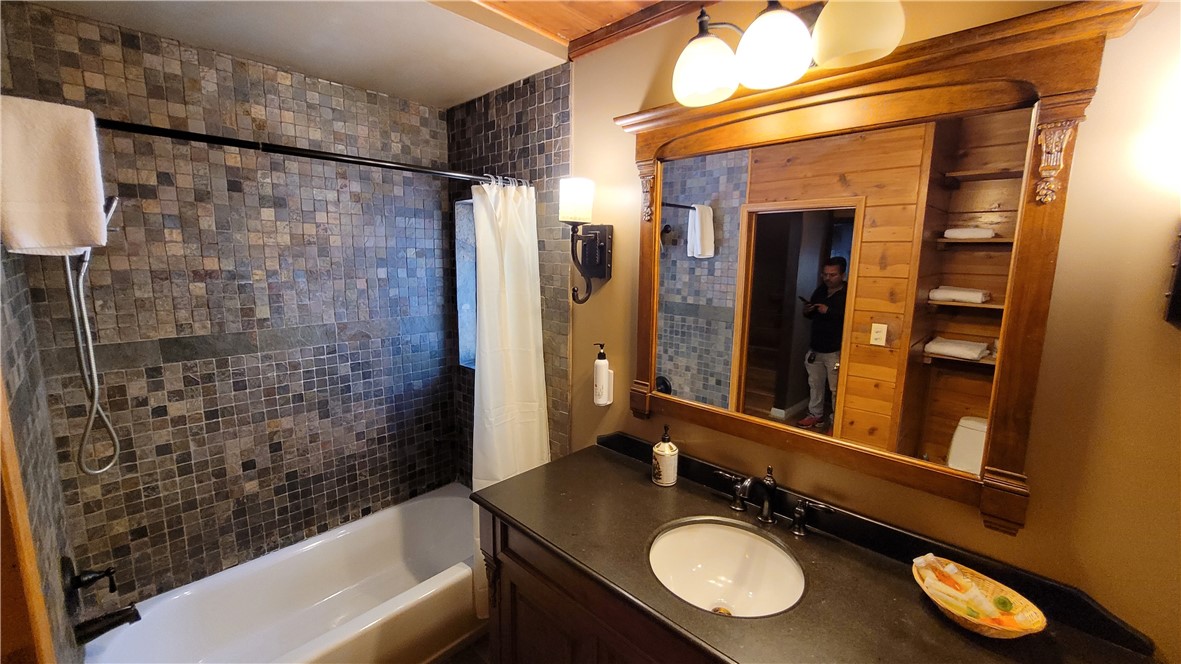42268 Moonridge Road Big Bear Lake, CA 92315 - Photo 29 of 54 a bathroom with a granite countertop sink mirror and a bathtub