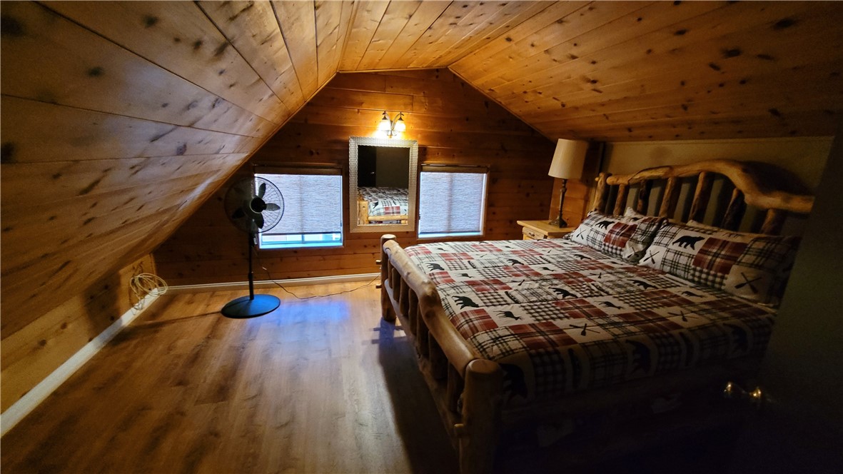 42268 Moonridge Road Big Bear Lake, CA 92315 - Photo 32 of 54 a bedroom with a bed and wooden floor