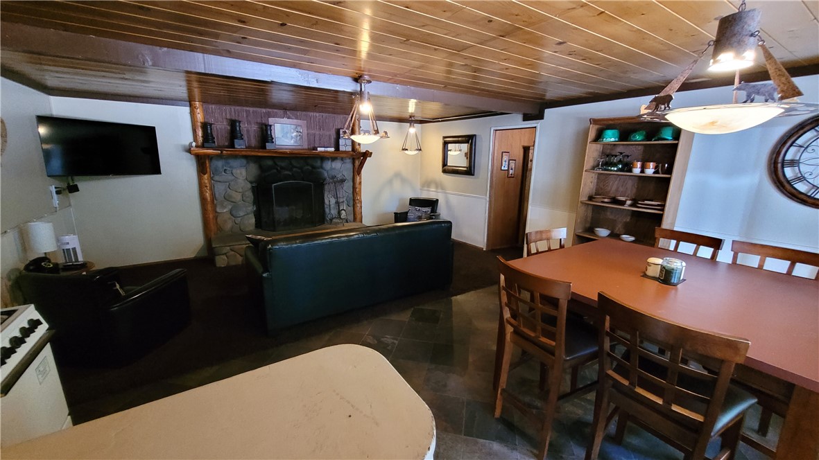 42268 Moonridge Road Big Bear Lake, CA 92315 - Photo 44 of 54 a living room with stainless steel appliances furniture a fireplace a flat screen tv and a view of kitchen