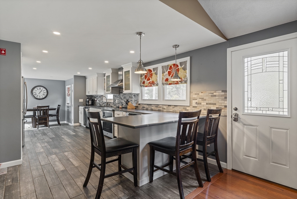 27 Leo's Lane Avon, MA 02322 - Photo 6 of 30 a kitchen with stainless steel appliances granite countertop a kitchen island a table and chairs in it