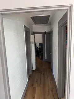 a view of a hallway with wooden floor and staircase