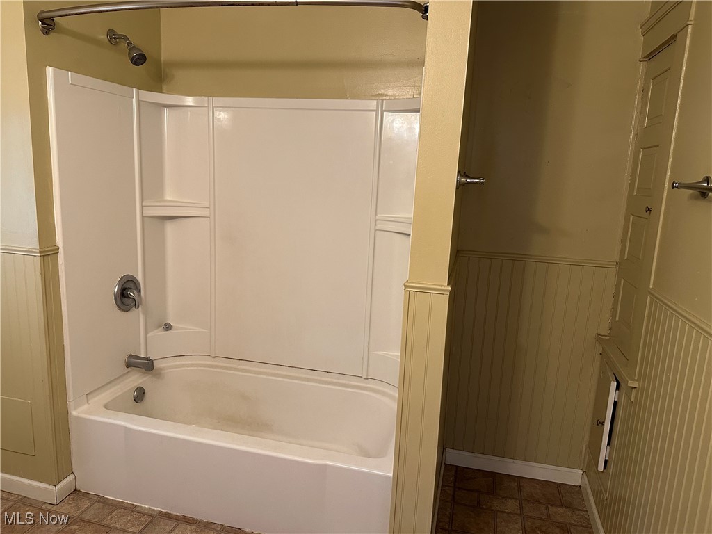 1596 Wood Road Cleveland Heights, OH 44121 - Photo 19 of 25 Full bath with a wainscoted wall, shower / bath combination, and stone finish floors