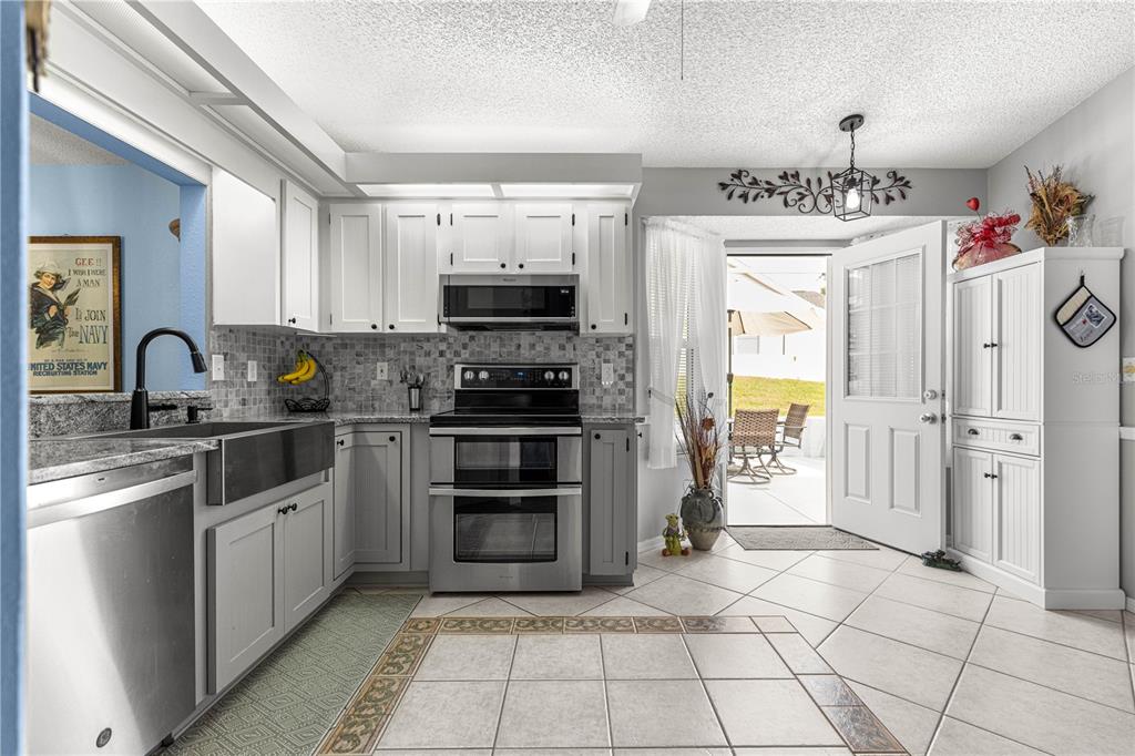 8145 Southwest 109th Street Ocala, FL 34481 - Photo 12 of 43 a kitchen with stainless steel appliances a refrigerator sink and cabinets