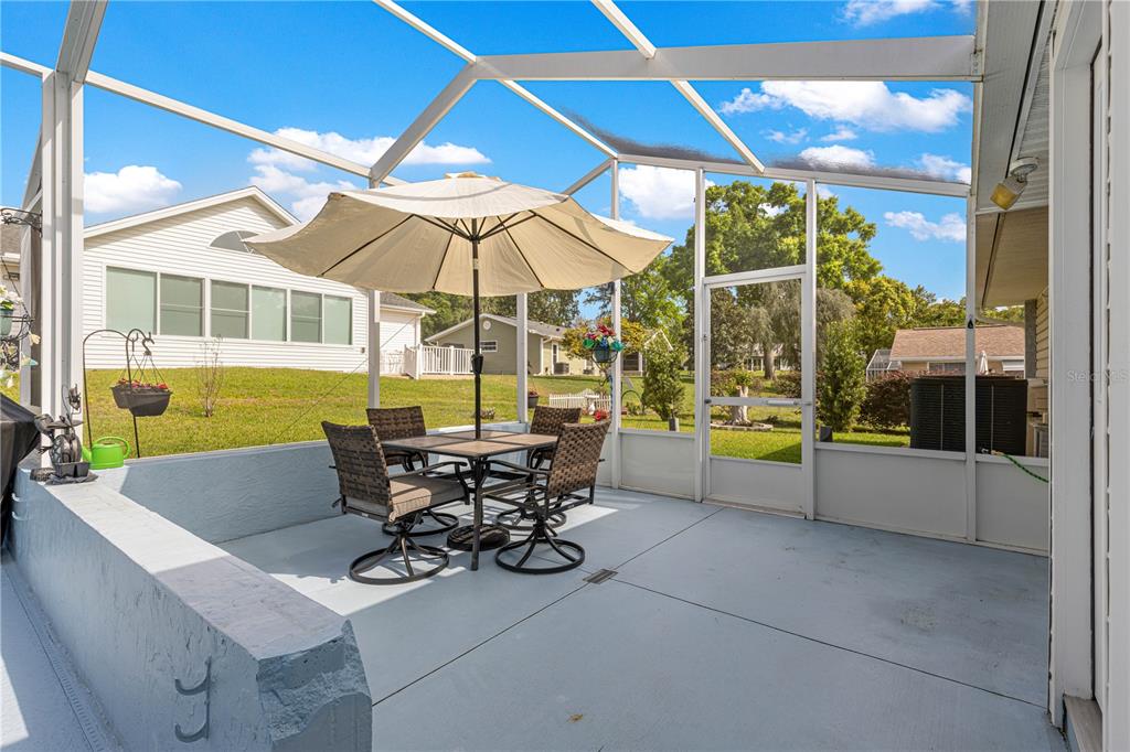 8145 Southwest 109th Street Ocala, FL 34481 - Photo 30 of 43 a view of a patio with a table and chairs under an umbrella