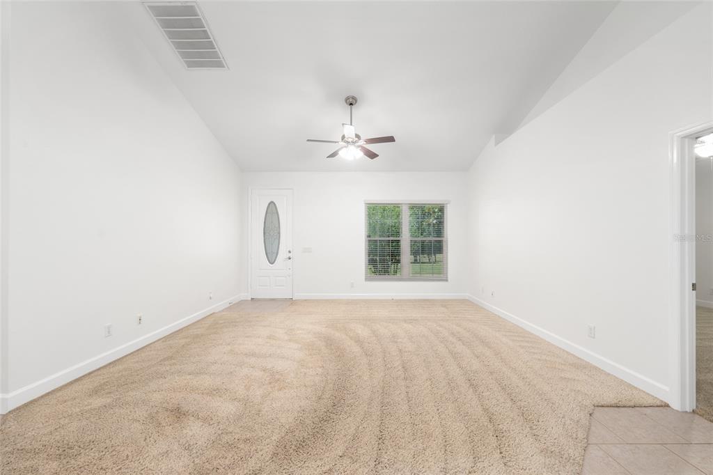 4735 Southeast 112th Street Road Belleview, FL 34420 - Photo 17 of 73 an empty room with chandelier fan and windows