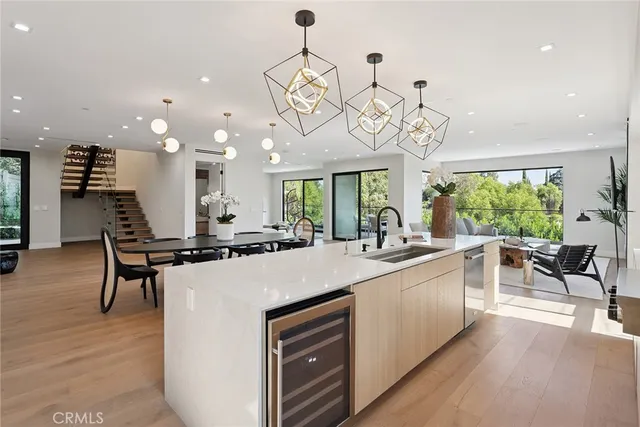 a kitchen with a dining table chairs stainless steel appliances and wooden floor