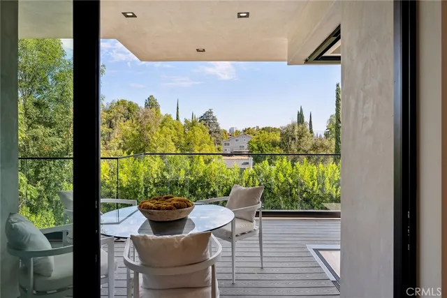 a view of a balcony with chairs and a potted plant