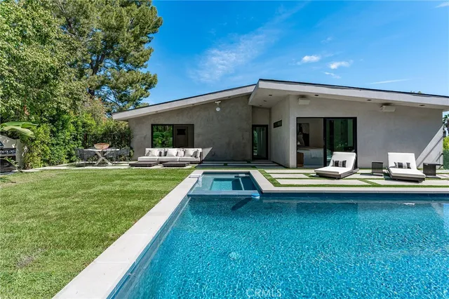 a swimming pool with outdoor seating and yard