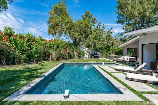 a view of house with swimming pool outdoor seating