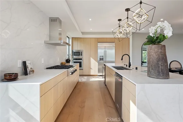 a large kitchen with a sink a counter space and wooden floor