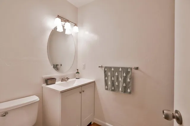 a bathroom with a sink mirror and toilet