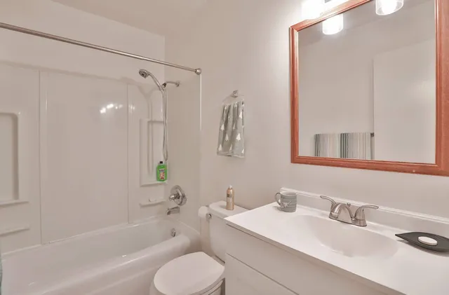 a bathroom with a granite countertop sink toilet and shower