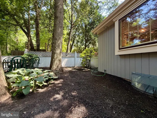 a view of a house with a yard and large tree