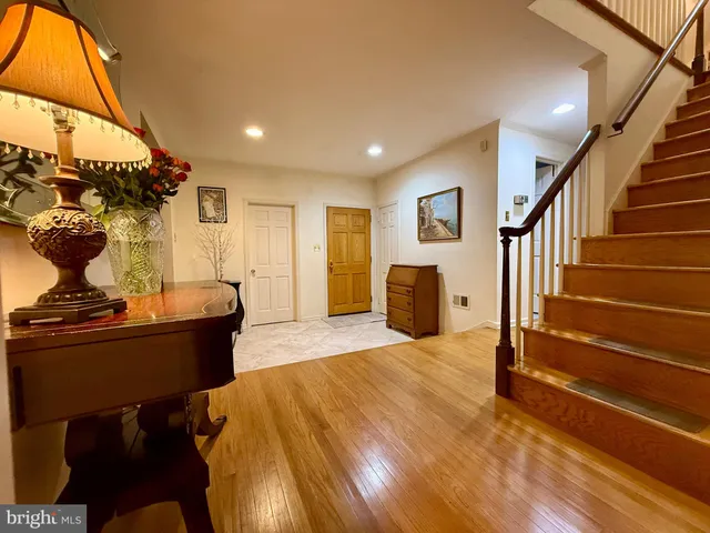a view of a hallway with wooden floor and stairs