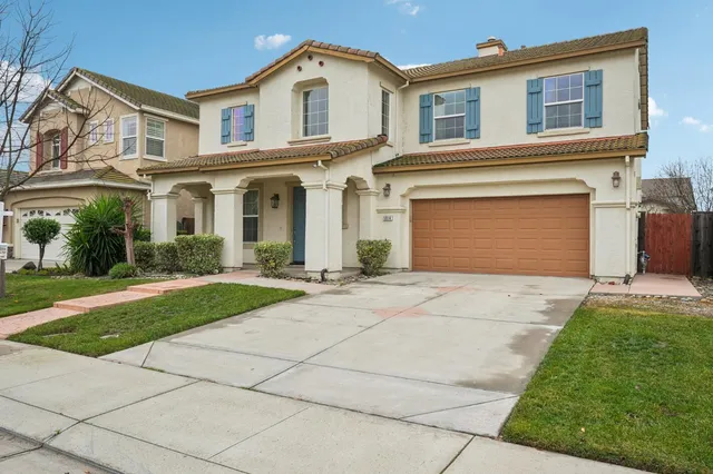 a front view of a house with a yard and a garage