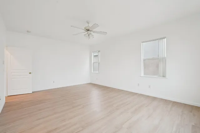 a view of a room with wooden floor and a ceiling fan