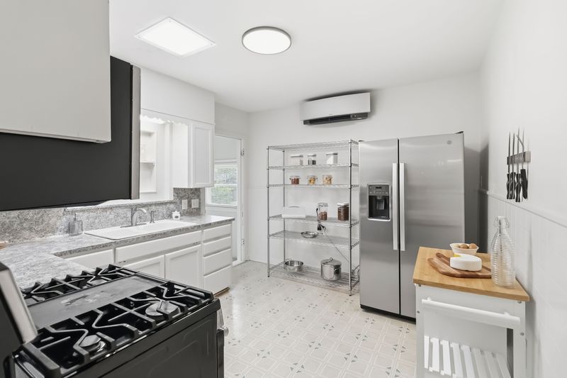 605 West 11th Street Elgin, TX 78621 - Photo 8 of 31 Kitchen featuring black range with gas stovetop, stainless steel fridge, white cabinetry, light flooring, and light countertops