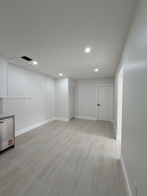 9007 Southwest 38th Street, Unit 9005 Miami, FL 33165 - Photo 4 of 7 an empty room with wooden floor and windows