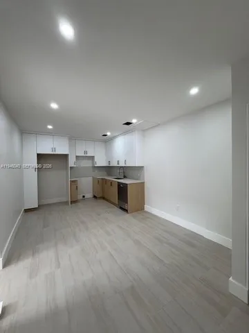 a large kitchen with a refrigerator and a stove top oven