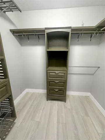 a view of walk in closet with clothes