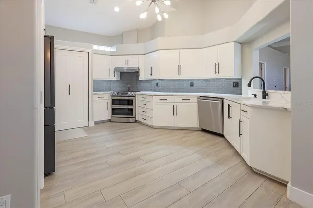 a large kitchen with cabinets a sink and appliances