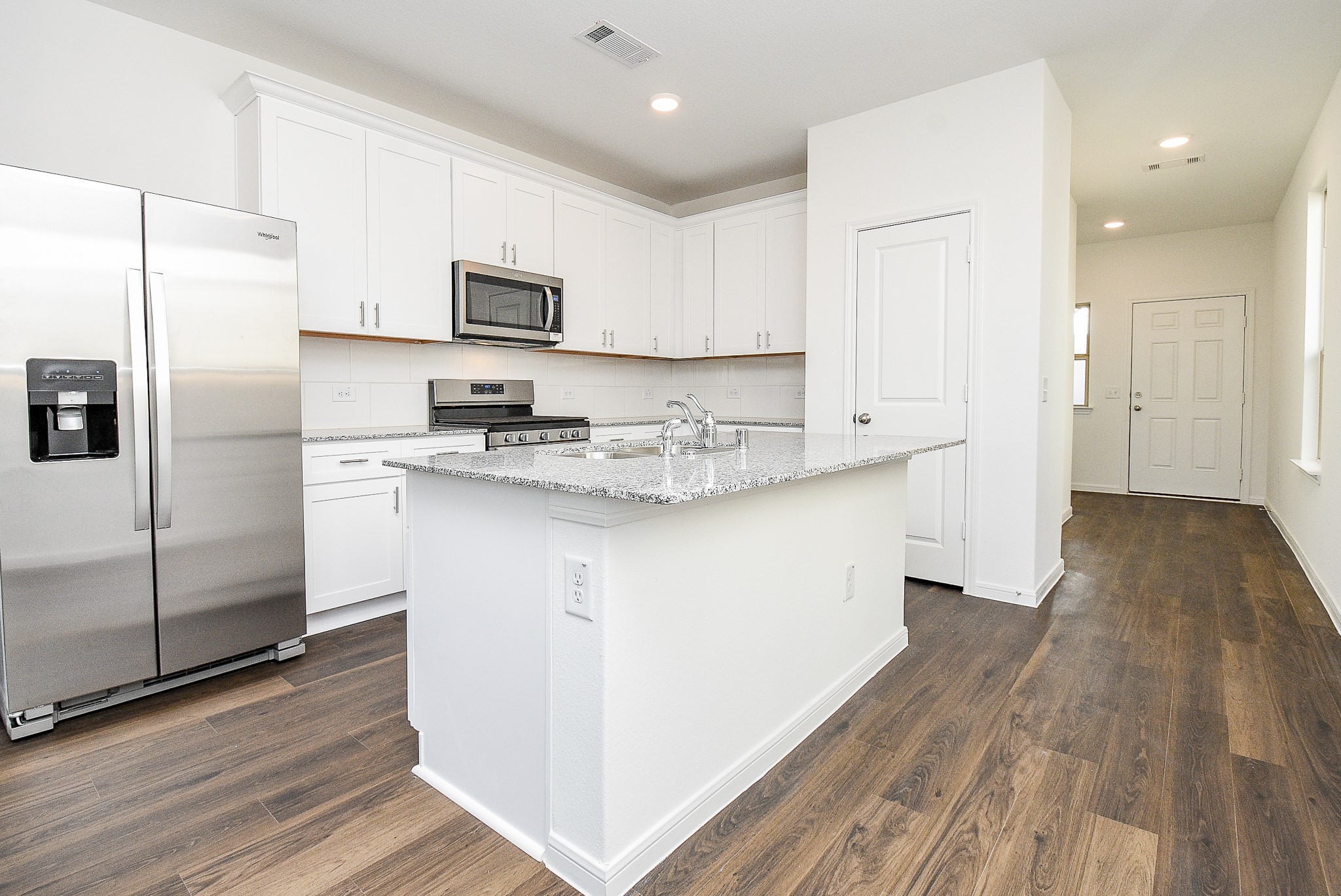 14499 Cedar Br Lane Conroe, TX 77302 - Photo 10 of 32 a kitchen with stainless steel appliances granite countertop a refrigerator a sink dishwasher a stove and white countertops with wooden floor
